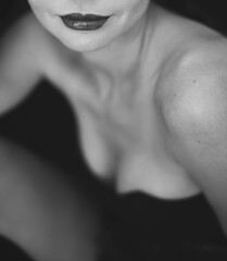 Beauty lips, shoulders, breast and neck of beautiful woman on black background. Fashion art Black and white sexy model portrait - obrazy, fototapety, plakaty