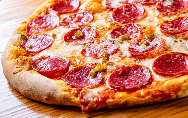 Hot Pepperoni Pizza with Mozzarella cheese, salami, Tomato sauce, pepper, Spices. Italian pizza on wooden background