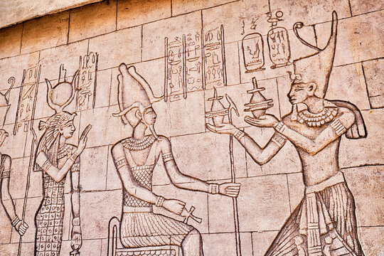 egyptian frescoes with carved figures of pharaohs and gods