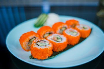 a roll with salmon and rice with tobiko caviar