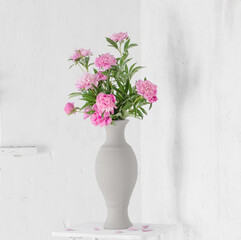 pink peony in ceramic vase on background old wall