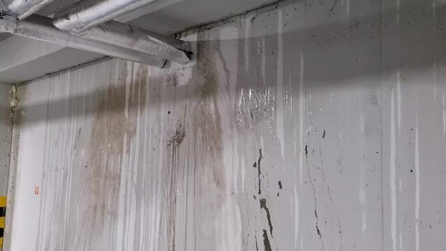Water stains on a concrete wall of an underground garage, pipe malfunction