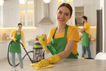 Team of professional janitors working in kitchen