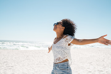 Carefree african american woman at beach with outstretched hands