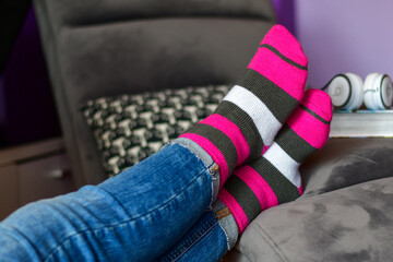 Close-up of woman wearing Magenta   socks while   resting for workout on a sofa at home. 