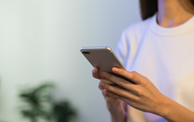 Hand holding smartphone and chatting with friends at social network on the table.
