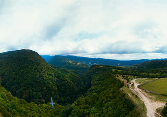 Okace canyon wide aerial view. The mountains are covered with green forest. Natural landscape. Vacation and Travel. Tourist place in Georgia. metal bridge to explore the area