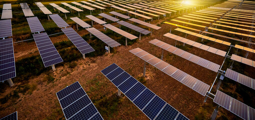 Aerial shot of sunrise sunlight shining on solar photovoltaic panels