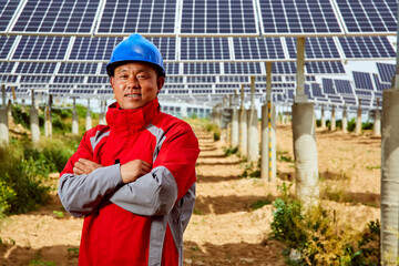 Image of Asian worker standing under solar photovoltaic panel