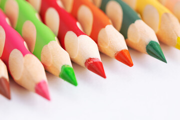 Color pencils on a white background with copy space. Ergonomic triangular colored pencil with...