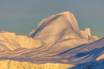Close up of a part of a huge iceberg in the warm light of the midnightsun in west Greenland
