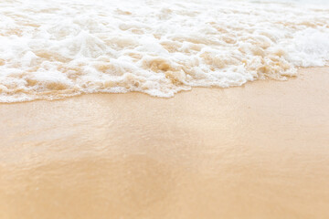 Beach sand sea water summer background. Sand beach desert texture. White foam wave sandy seashore top view