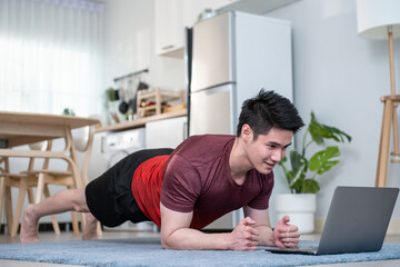Asian handsome active young man doing exercise on floor in living room