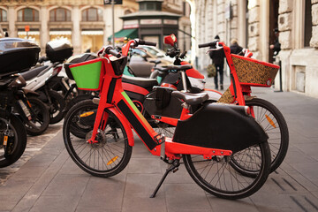 Fototapeta na wymiar Rent of orange bikes in Rome a shared bike in city