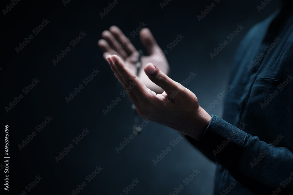 Wall mural Muslim man praying on dark background