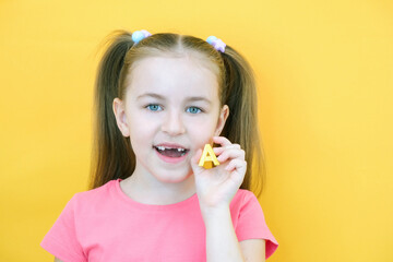speech therapy. Toddler girl holding the letter A in her hands. Classes with a speech therapist. Girl on isolated yellow