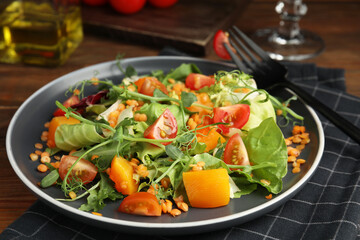 Delicious salad with lentils and vegetables served on wooden table, closeup