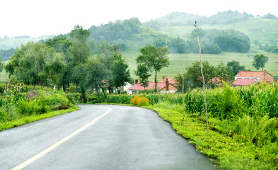 Fototapeta na wymiar Asphalt road leading to the mountain village in China