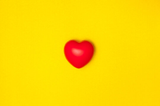 Top view or flat lay of red heart pillow on yellow background with copy space, isolated. Valentine's day concept.
