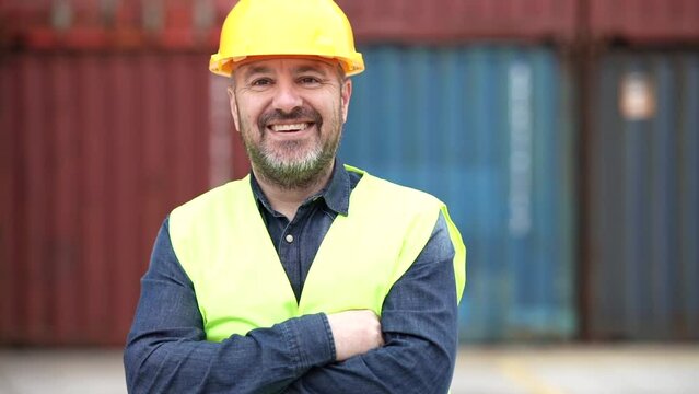 male container worker in port with helmet and reflective vest Caucasian man - concept of work in port cargo -