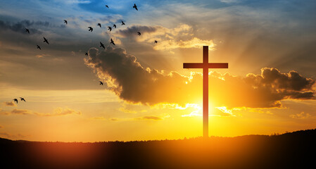 Christian cross on hill outdoors at sunrise. Resurrection of Jesus. Concept photo.