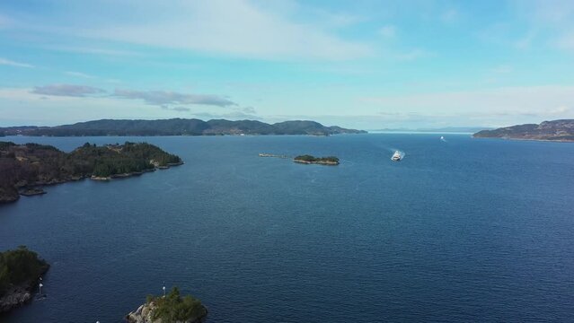 Torghatten ferry Flatoy is approaching Sandvikvaag with Bjornafjorden sea in background - Static aerial overview Norway