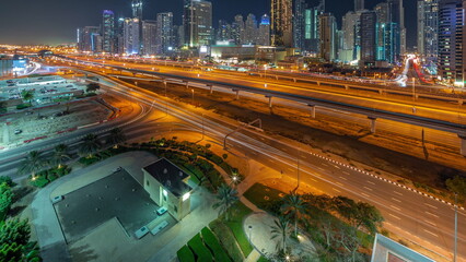 Fototapeta na wymiar Dubai Marina skyscrapers and Sheikh Zayed road with metro railway aerial all night timelapse, United Arab Emirates