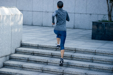 Fitness woman running up stairs in city