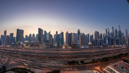 Naklejka na ściany i meble Panorama of Dubai Marina skyscrapers and Sheikh Zayed road with metro railway aerial day to night timelapse, United Arab Emirates