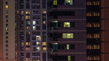 Fototapeta na wymiar Night night view of multicolor light in windows of multistory buildings aerial timelapse.