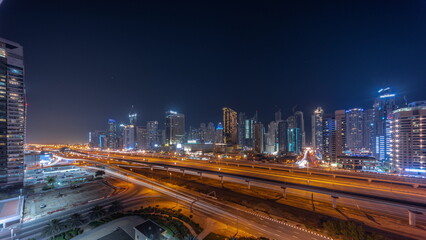 Fototapeta na wymiar Panorama of Dubai Marina skyscrapers and Sheikh Zayed road with metro railway aerial all night timelapse, United Arab Emirates