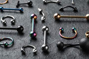 Stylish jewelry for piercing on grey table, closeup