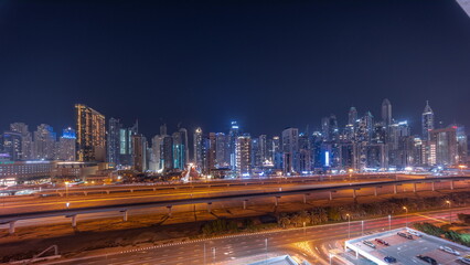 Fototapeta premium Panorama of Dubai marina tallest block of skyscrapers all night timelapse.