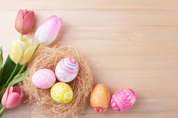 Happy Easter day eggs in nest and flower on wood background with copy space