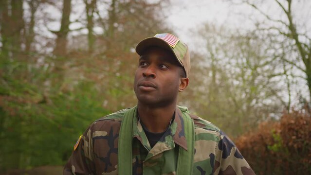 Front view of soldier in camouflage uniform carrying kit bag walking home to see family on leave - shot in slow motion