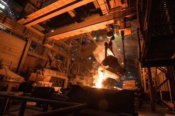 Tank pours liquid metal in the molds at the steel mill. Interior of a steel mill.