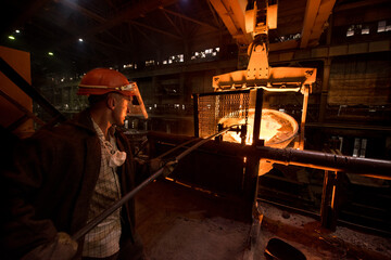 Obraz na płótnie Canvas Steelworker at work near the tanks with hot metal