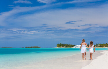 Healthy young Caucasian siblings walking along Caribbean beach