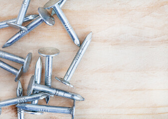 rustic silver nails on raw wooden surface with copy space