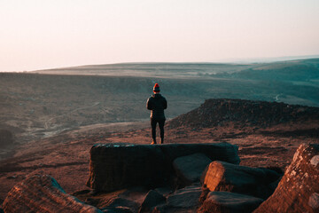 Person watching the mountain on Higger Tor in Peak District National Park , England, UK