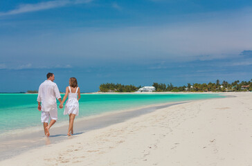 Romantic Caucasian couple walking on a beach together