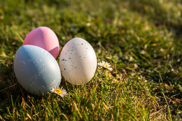 Happy Easter. Easter eggs on grass on a sunny spring day - Easter decoration, banner, panorama, background with copy space for text.