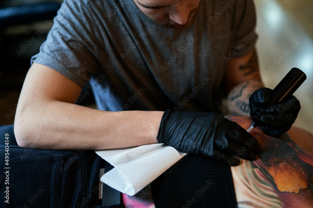 Sticker Focus caucasian man tattooing back of woman at the studio