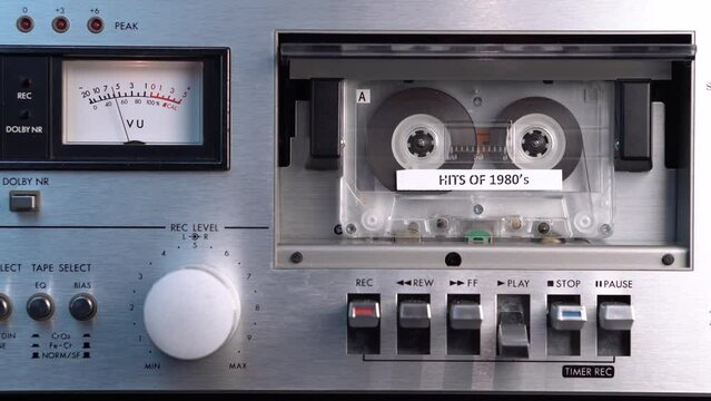 Hits of 1980's Audio Cassette Tape Playing in Deck, Vintage Music Compilation on Old Analog Media, Close Up