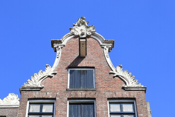 Fototapeta na wymiar Amsterdam Haarlemmerstraat Street Bell Gable Close Up Against a Bright Blue Sky, Netherlands
