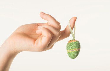 hands holding easter egg on white background closeup