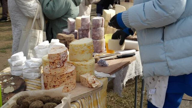 Farmers hand makes Swiss cheeses from her own cows. Food Market in Europe. Local produce market in an outdoor space