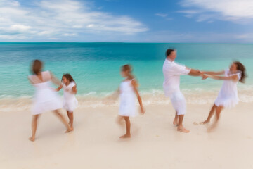 Fototapeta na wymiar Caucasian parents and daughters playing on island beach