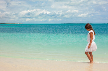 Healthy young Caucasian girl walking along Caribbean beach