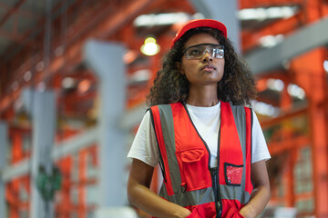 Portrait of Young African American technicians in safety vest and glasses with red helmet standing...